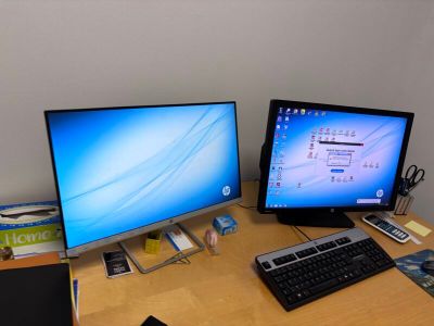 deux écrans et un clavier sur le bureau