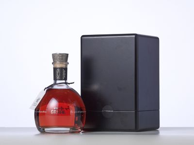 une bouteille de vin rouge posée à côté d'une boîte noire