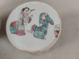 a small plate with a painting on it sitting on a table