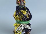 une petite figurine représentant une femme vêtue d'une robe jaune et noire