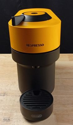une cafetière orange et noire posée sur une table en bois