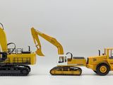 two toy construction vehicles that are sitting next to each other