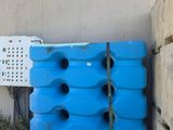 un grand conteneur bleu posé contre un mur