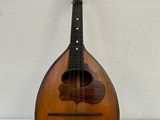 an old mandolin sitting on top of a table next to a white wall