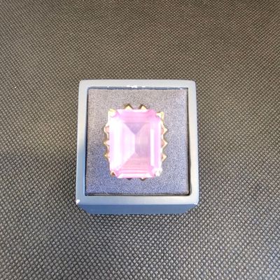 une photo d'une bague rose posée dans une boîte sur une table