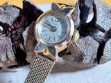 a silver watch sitting on top of a silver bracelet