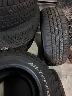 tires are stacked on the floor next to a pile of other tires