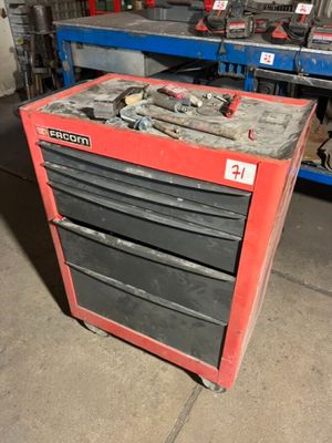 a red tool chest with tools on it in a garage