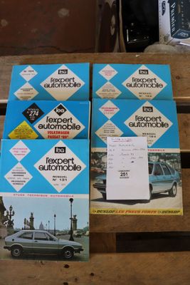 plusieurs livres posés sur une table en bois, avec une voiture en arrière-plan
