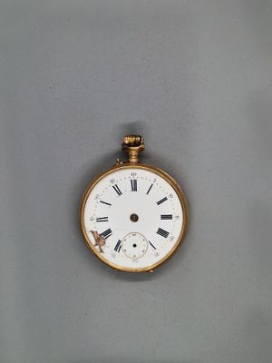 une montre de poche en or avec des chiffres romains sur le cadran
