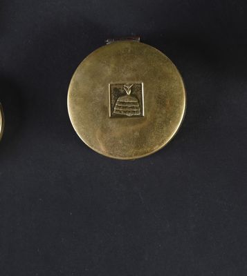 two gold plated watches on a black surface with a black background