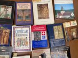 several books on a table with a clock and other religious books