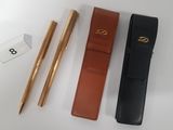 two pens and a pen case sitting on top of a table