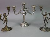 three silver colored candlesticks sitting next to each other on a table