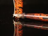 a pen that is sitting on a table with a reflection on it
