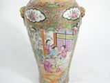 a vase with a painting on it sitting on a table