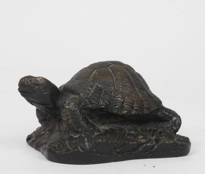 une statue représentant une tortue assise sur un rocher