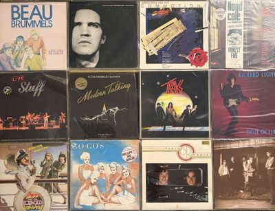 many different album covers on the wall of a room