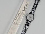 La montre est noire et blanche, avec un motif floral.