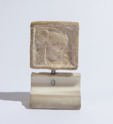 sculpture représentant une femme, posée sur un bloc de pierre reposant sur un socle en bois