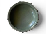 a green bowl sitting on top of a white table