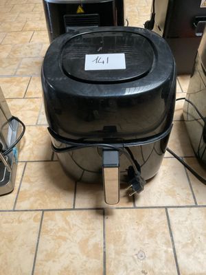 une poubelle noire posée par terre à côté d'autres poubelles