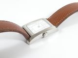 an image of a watch with a brown leather strap on a white surface