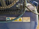 a close up of a blue air compressor on the ground