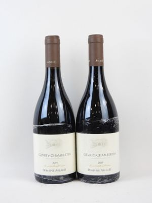 deux bouteilles de vin posées l'une à côté de l'autre sur une surface blanche