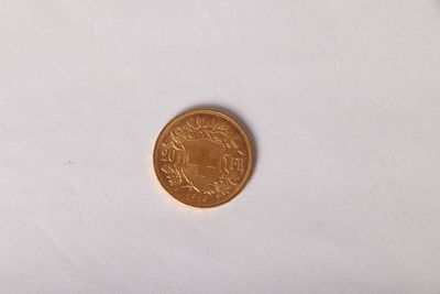 a gold coin on a white surface with a white background