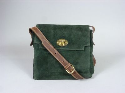 un sac à bandoulière vert en daim, muni d'une bandoulière en cuir marron