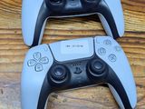 two video game controllers sitting on a wooden table