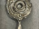 a silver mirror on the wall with a silver handle