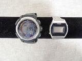 two watches sitting on a black band on a table