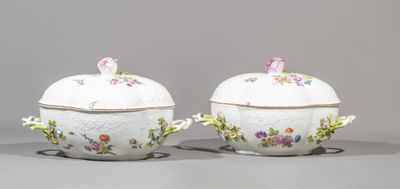 pair of porcelain covered dishes with floral designs on them on a gray surface