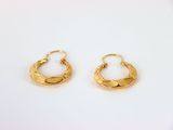 une paire de boucles d'oreilles en or sur fond blanc