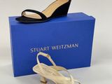 une paire de chaussures noires et blanches posée sur une boîte bleue