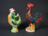 two figurines of roosters standing next to each other