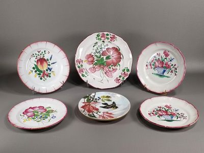 plusieurs assiettes ornées de fleurs et d'oiseaux sur un fond gris