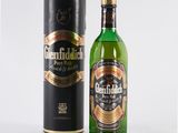 an image of a bottle of green liquor next to a black box