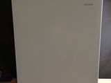 an image of a small white refrigerator on a wooden table