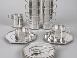 a group of silver plated dishes and cups on a table