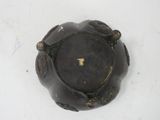 a small black vase with a gold decoration on it