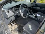 the interior of a car with the door open and the driver ' s seat down