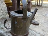 a small watering can sitting on a stone slab
