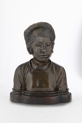 une statue en bronze représentant une femme assise sur une table