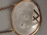 a gold necklace with a picture of a cross on it