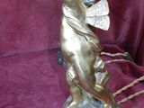 bronze figurine of a child with a fan on a purple cloth