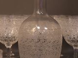 bottles and glasses are lined up on a table in front of a wall
