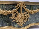 a gold and green marble box with a bird on it
